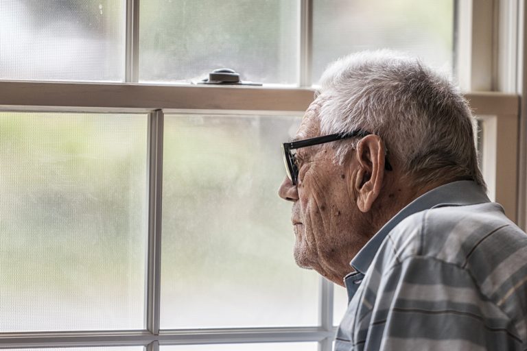 Wistful Senior Man Staring Through Hazy Window