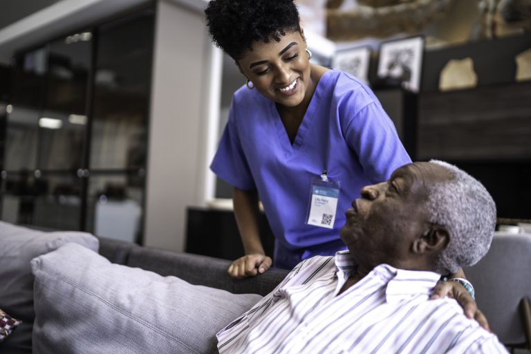 Female nurse taking care of a senior man at home