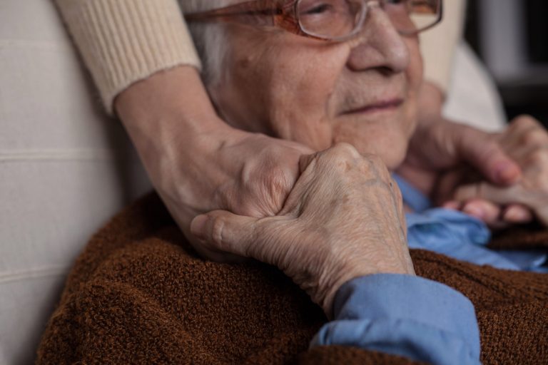 senior woman holding hands with someone