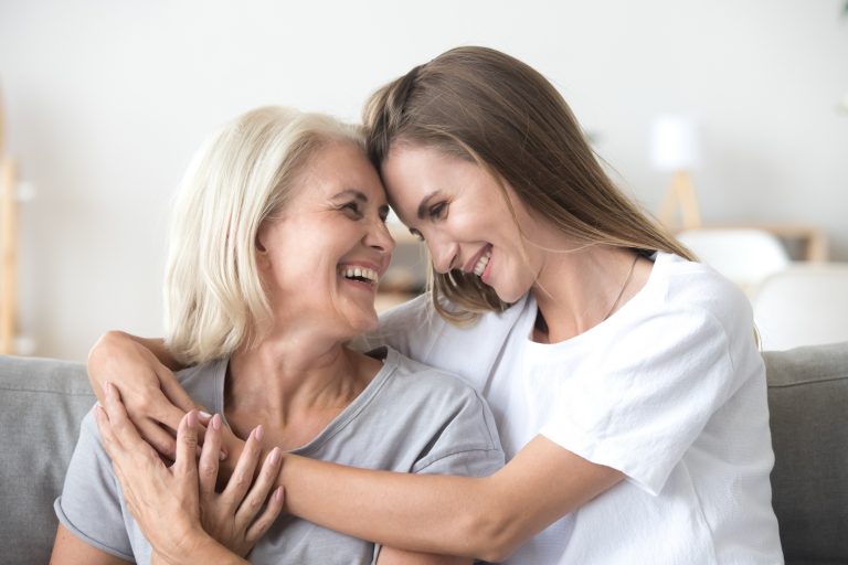 Mother and daughter smiling and embracing