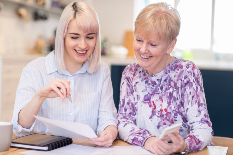 Financial Advisor Helping Senior Neighbor With Paperwork