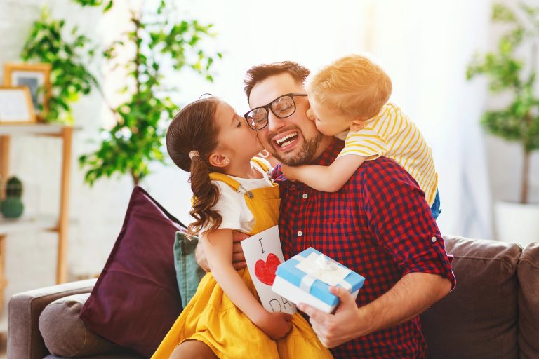 Happy father's day! Children congratulates dad and gives him gift and postcard