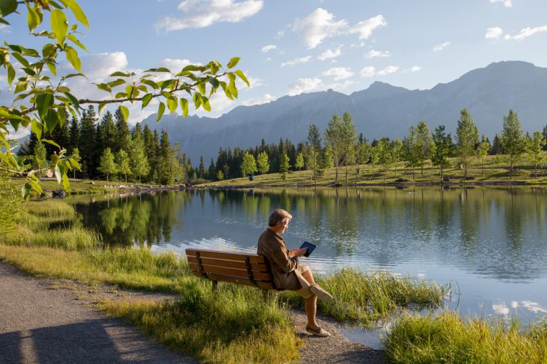 Man uses digital tablet in the morning by the lake