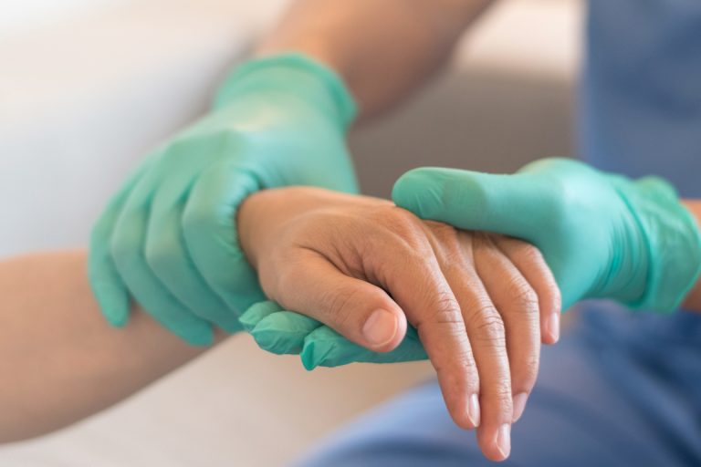 physician checks hand of patient